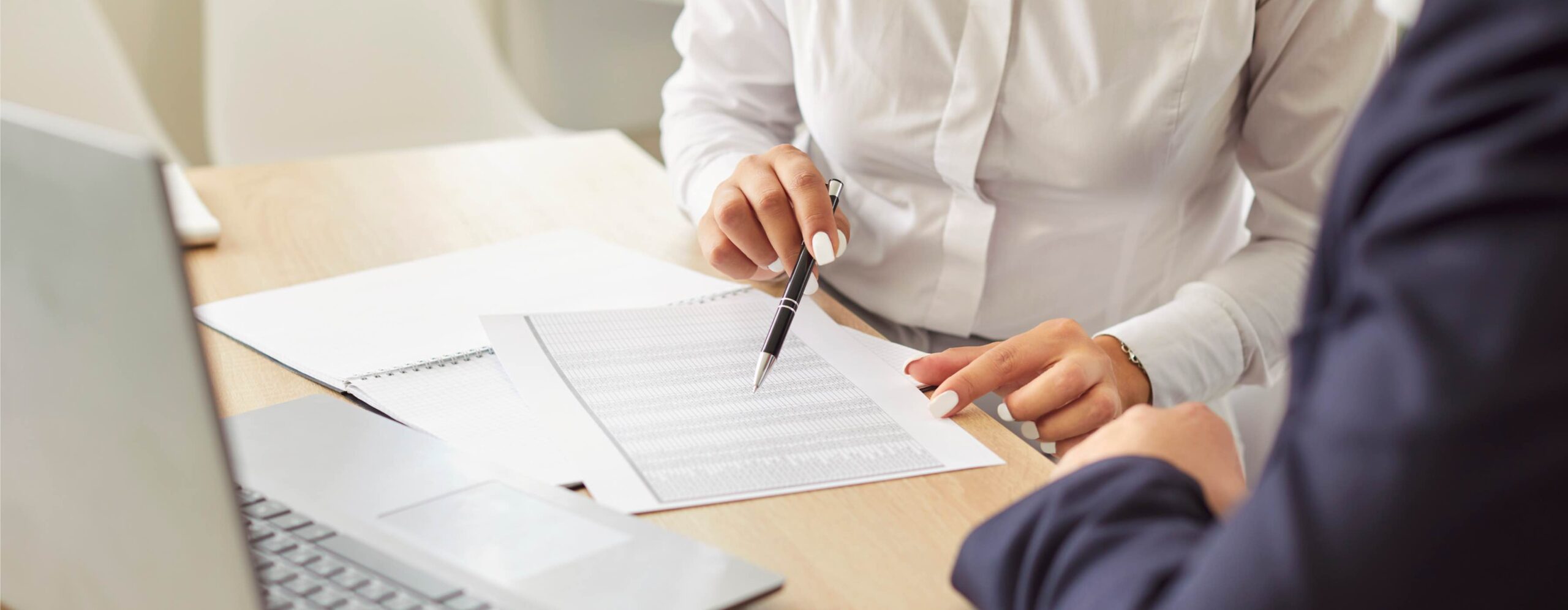 Business people in an office working together on papers, engaging in accounting or audit tasks. Negotiation and meeting highlight an inspection process, ensuring accurate financial assessments.