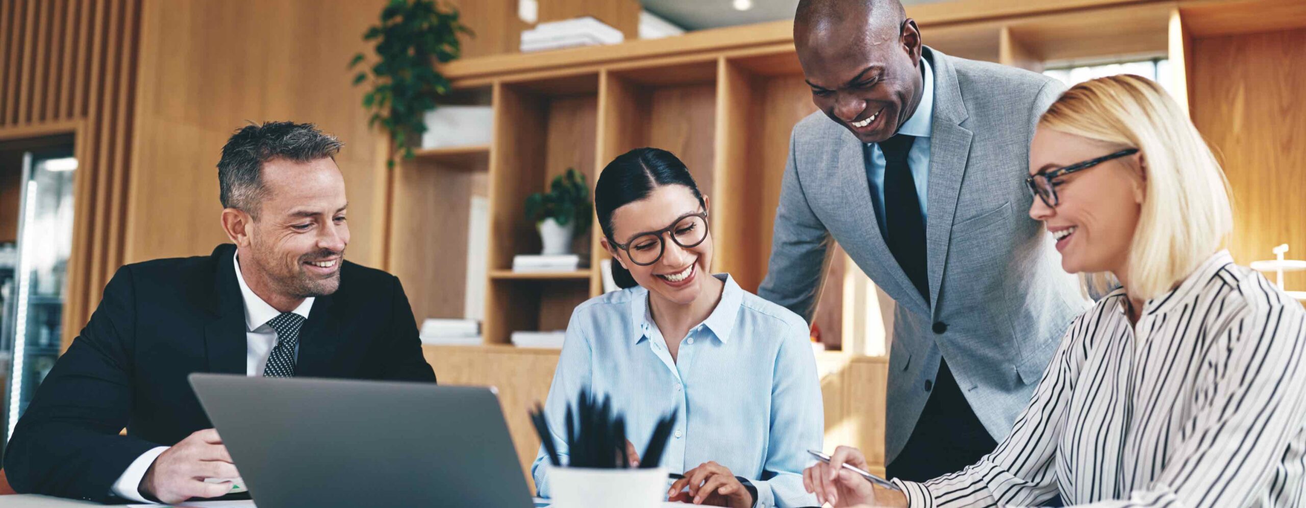 Diverse group of businesspeople laughing together during an office meeting